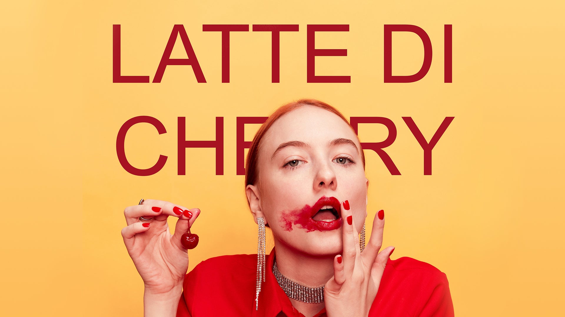 Il s'agit de la bannière du produit de New Notes : "Latte di Cherry". Nous y voyons une femme avec un chemisier rouge et des bijoux. Elle tient dans sa main droite une cerise. Sa main gauche, elle essuie le contour de ses lèvres. Le titre du produit est noté en gros plan, en arrière plan.